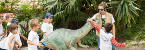 Atrações da Vila Encantada: foto de crianças brincando com um modelo de dinossauro