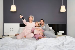 mãe, filha e pai juntos se preparando para assistir um filme de dinossauro infantil