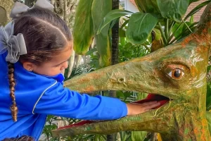 menina fazendo atividades com dinossauro na escola