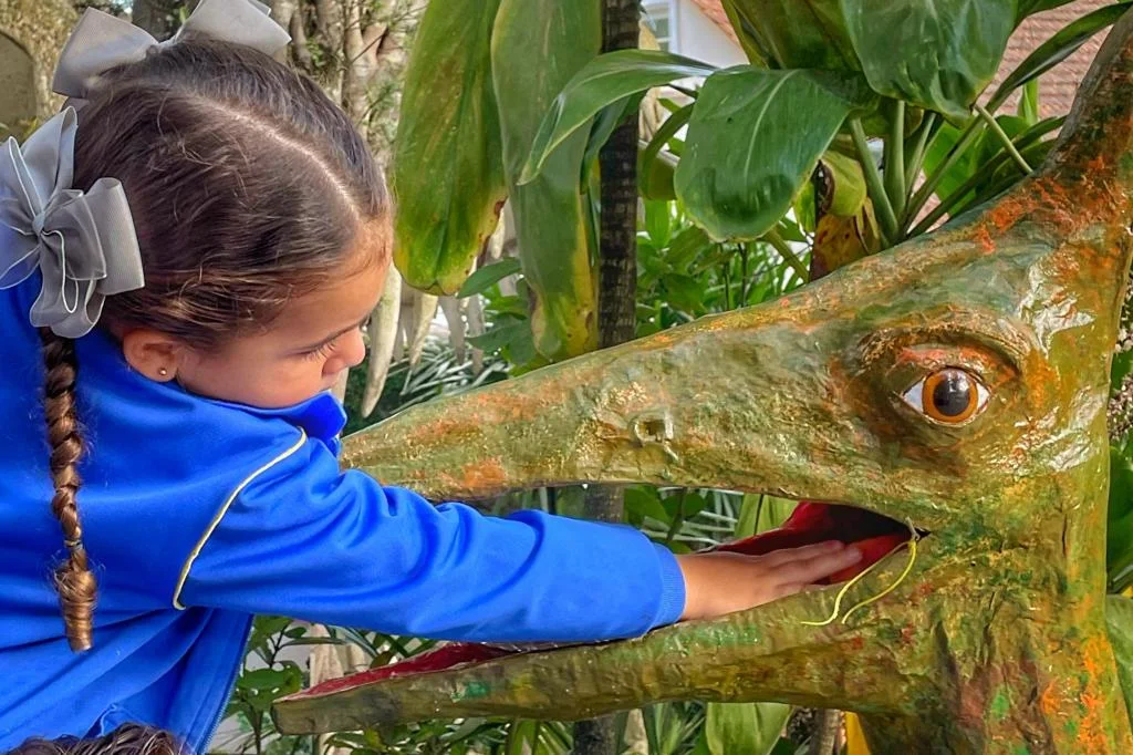 menina fazendo atividades com dinossauro na escola