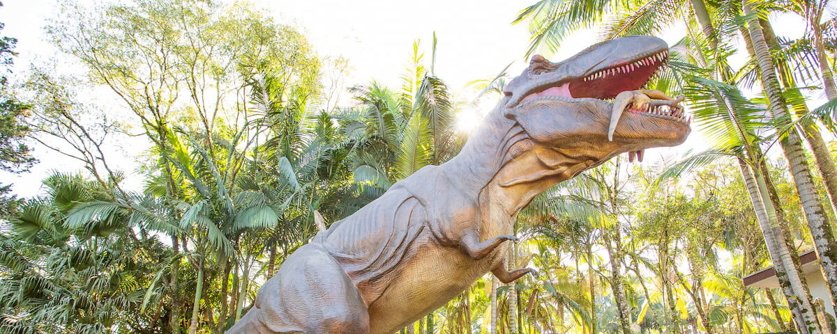 Imagem de réplica de dinossauro na Vila dos Dinossauros, representando uma das atrações para crianças.
