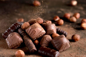 Diferentes tipos de chocolates sobre uma mesa, representando a fábrica de chocolates Nugali.