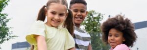 três crianças brincando em um parque e aproveitando todos os benefícios que a brincadeira proporciona no desenvolvimento infantil