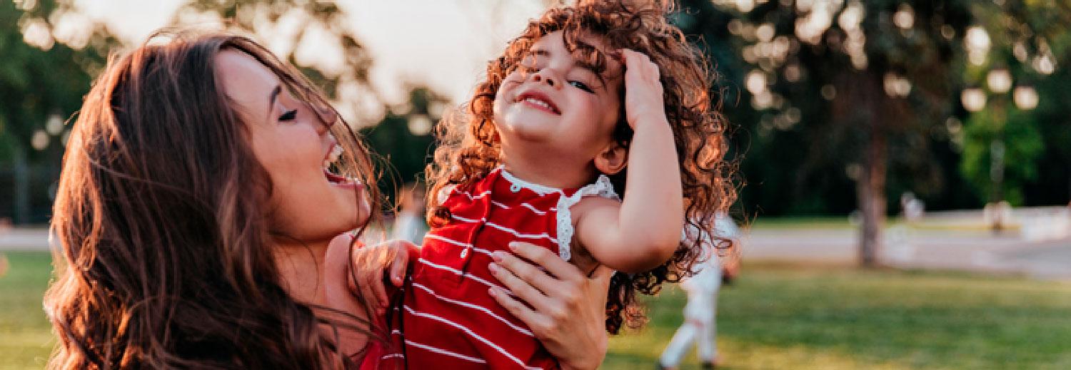 uma mãe segurando a sua filha nos braços em um dia de visita a cidade de Pomerode no dia das mães